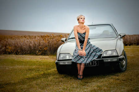 beautiful blonde woman walking near the retro car near lavender field at french styleのeditorial素材