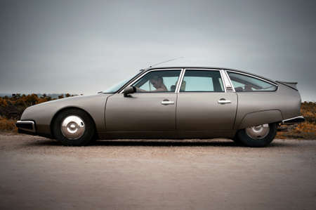 Citroen CX 2000, 80th, france classic car and woman dressed in vintage style, at rainy day, relax moodのeditorial素材