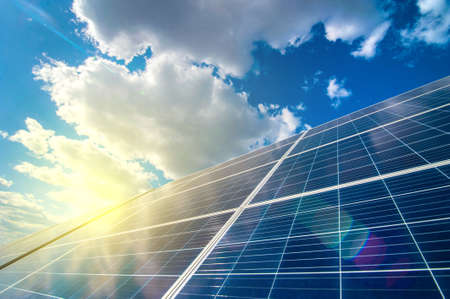 Solar energy panel power system, view up on the sky with clouds and sun raysの写真素材