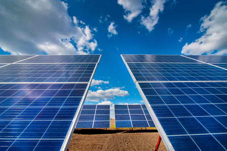 solar power station panels, with reflection of clouds and skyの写真素材