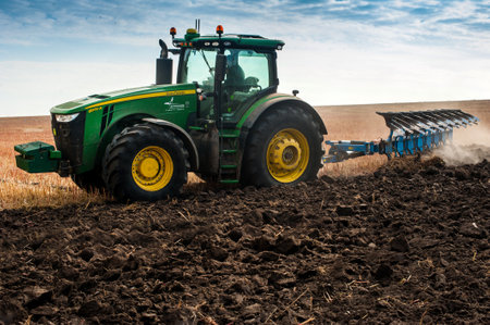 Baykivtsi, Ternopil region, Ukraine - October 18, 2019: John Deere 8370r farm tractor plows the...