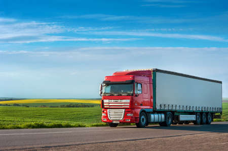 LANIVTSI, TERNOPIL REGION, UKRAINE - MAY 19, 2020: Large truck on the route along the route with colored fieldsのeditorial素材