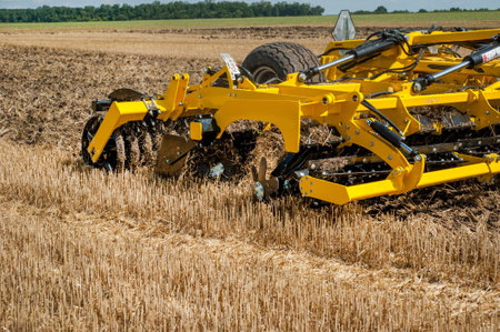 cultivator at work, close up of a disc harrow on a field backgroundのeditorial素材