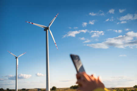 The specialist uses a gadget to control the parameters of wind turbines.の写真素材