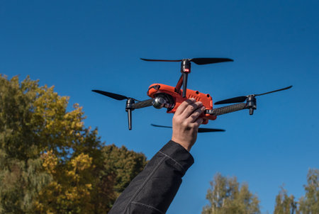 man's hand holds the drone ready to fly