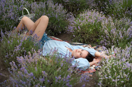 Young woman lying in lavender field, dreams, relaxation and peaceの写真素材