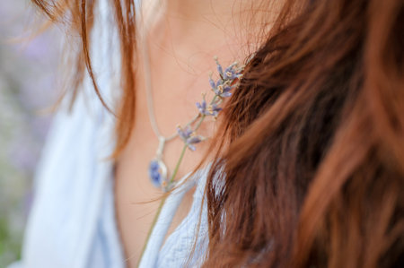 woman holding lavender flower, focus on flower hair and fragment of shirt