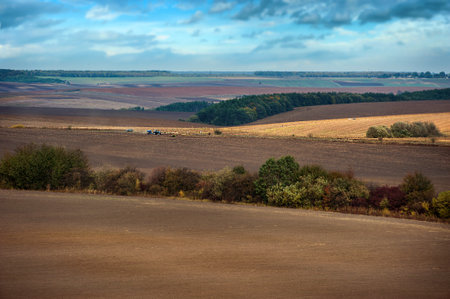 Agriculture plowed field on an autumn day. Black soil plowed field on the hills. A plowed field with...