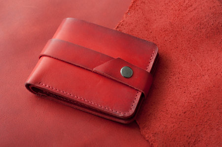 Red genuine leather wallet on the table, accessories for men, handmade products of small businessの写真素材