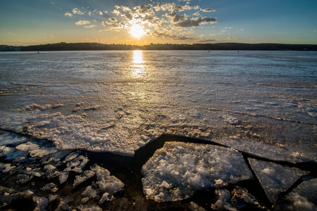 Spring cracks on the ice of the river, view at sunset. beauty of nature.の写真素材