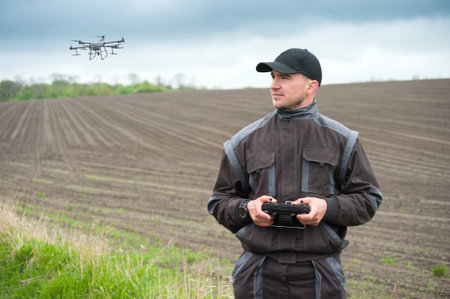 operator of an agricultural drone with a remote control, drone control for field sprayingの写真素材
