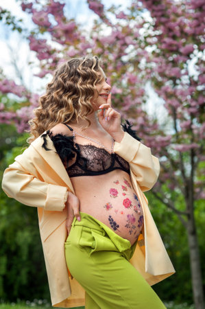 pregnancy, a young mother in a stylish bright outfit, a happy girl has the secret of a new lifeの写真素材