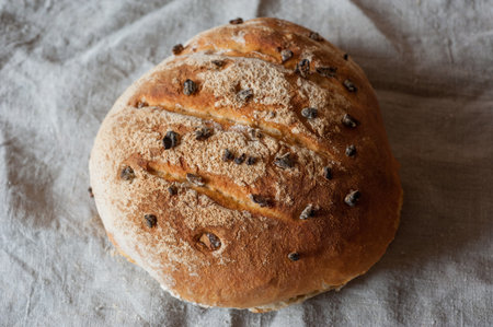 Homemade sourdough bread with raisins, nicely baked with a crust, on gray cloth, top viewの写真素材