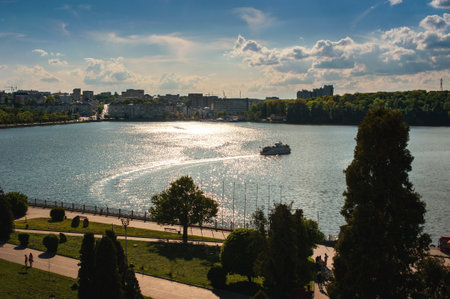 A panoramic view from above of a beautiful lake with a silhouette of trees and a boat. Embankment of Ternopil, Ukraine.の写真素材