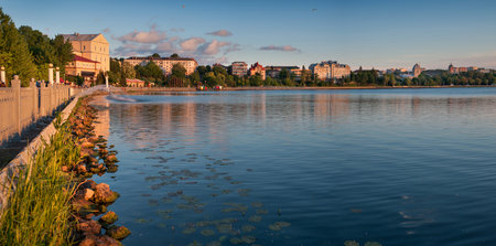 A wonderful panoramic view of a beautiful lake, embankment with a castle, silhouette of a church and city buildings on the background of the evening sky, Ternopil, Ukraine.の写真素材