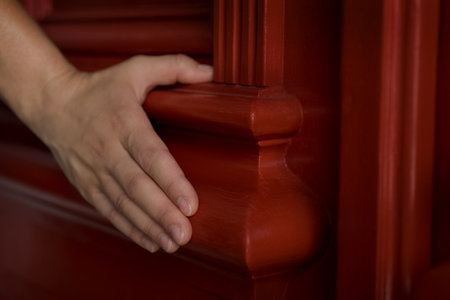 close-up of elements of a restored door with carved decor with a chamfer and a touch of a woman's hand.の写真素材