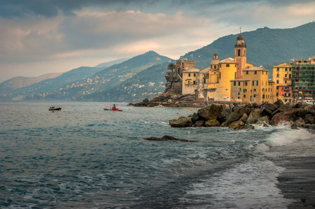 The picturesque coast with turquoise waves Mediterranean sea and colorful houses, tower of church against a backdrop of mountains at Camogli, Ligure, Italy.の写真素材