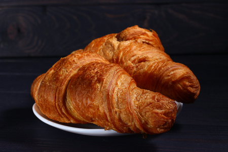 Croissants on a plate on a dark backgroundの写真素材