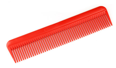 Red comb for combing hair on a white background isolate