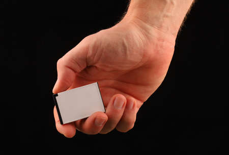 Camera battery in hand on a black backgroundの写真素材