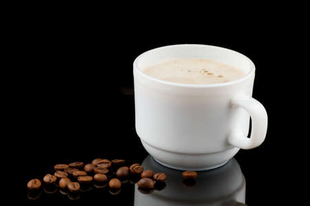 Cappuccino in a cup and coffee beans on a black backgroundの写真素材