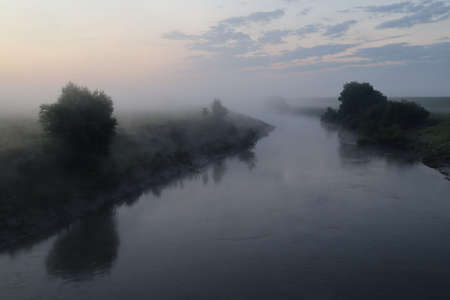 Gloomy river in the morning with fogの写真素材