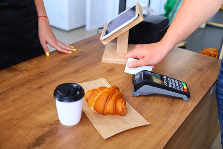 The buyer in the cafe pays by card