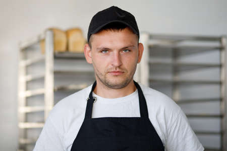 Young baker worker in a bakery in uniformの写真素材