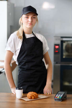 Beautiful girl sells coffee and pastriesの写真素材
