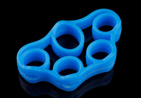 Rubber exercise machine for stretching fingers on a black backgroundの写真素材