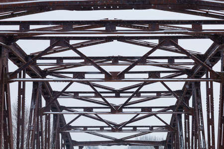 Old rusty metal bridge metal structure in winterの写真素材