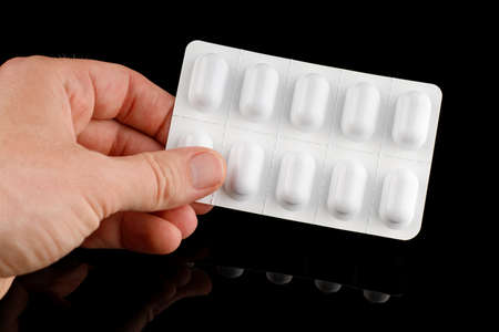 Pills in a white blister in handの写真素材