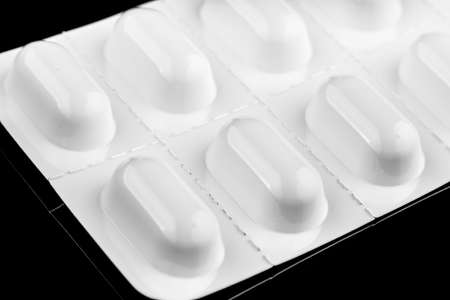 Pills in a white blister black backgroundの写真素材