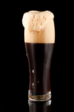 Dark unfiltered beer with foamの写真素材
