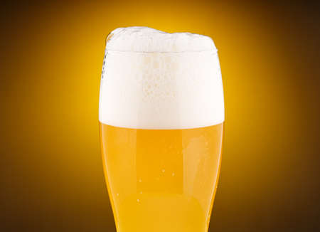 Light unfiltered beer with foamの写真素材