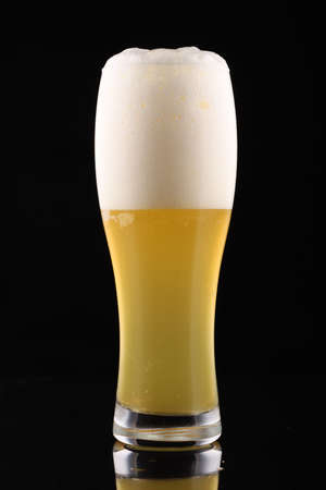 Unfiltered light beer in a glass on black backgroundの写真素材