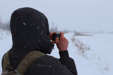 Man taking pictures in winter on smartphone place for text cope spaceの写真素材