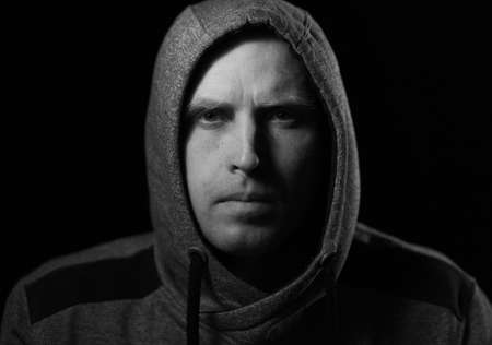 Portrait of a man in a hood dark keyの写真素材