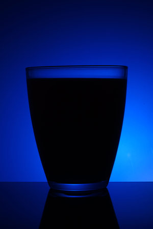 Glass of liquid and blue backgroundの写真素材