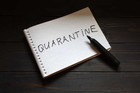 Quarantine lettering on notepad and a penの写真素材