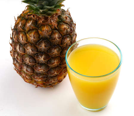 Pineapple and juice in a glass on a white backgroundの写真素材