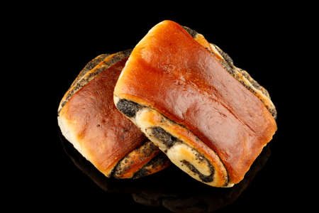 Bun with poppy seeds and muffins on a black backgroundの写真素材