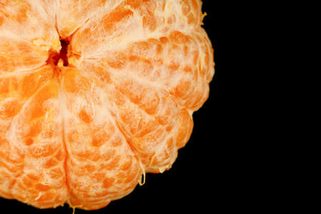 Peeled healthy tangerine fruit close-up on a black backgroundの写真素材