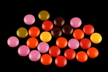 Colored round chocolates or chewing gum on a black backgroundの写真素材