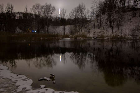 Cloudy and scary lake in winter at nightの写真素材