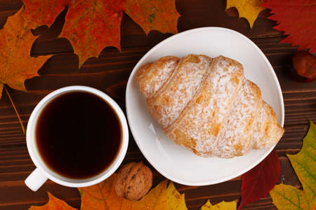 Cup of coffee and croissant autumn still lifeの写真素材
