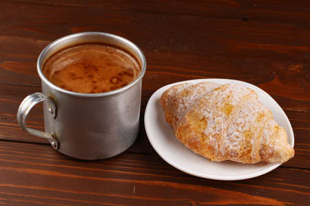 Cup of cappuccino and croissant on the tableの写真素材