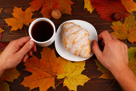 Cup of coffee and croissant autumn still lifeの写真素材