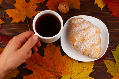 Cup of coffee and croissant autumn still lifeの写真素材