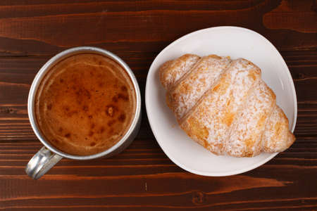 Cup of cappuccino and croissant on the tableの写真素材